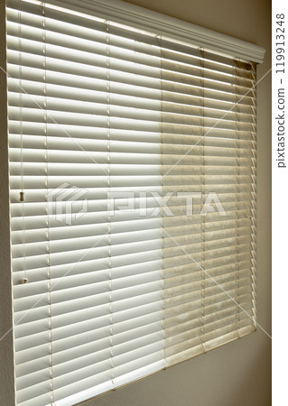 Residential Window Shades Showing the Before and After of a Good Cleaning - One Side Clean and One Side Dirty. 119913248