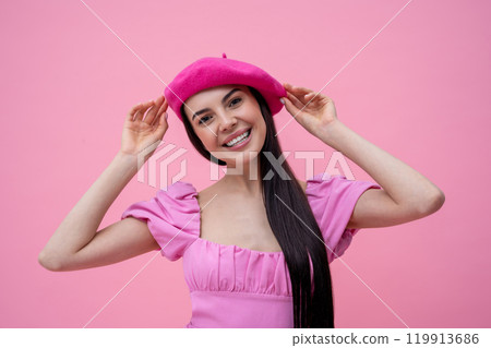 Beautiful you woman in pink dress and pink beret smiling happily 119913686