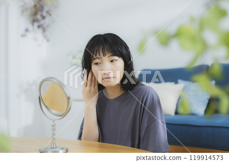 Young woman in loungewear doing skin care Young woman in loungewear doing skin care 119914573
