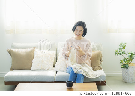 一位中年婦女在客廳織毛衣 一位中年婦女在客廳織毛衣 119914603