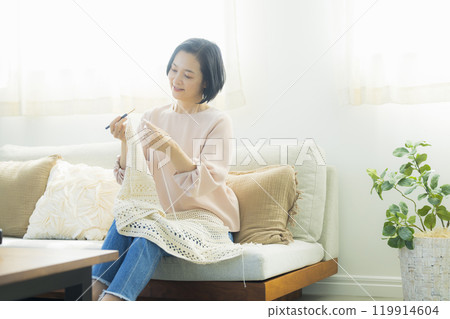 一位中年婦女在客廳織毛衣 一位中年婦女在客廳織毛衣 119914604