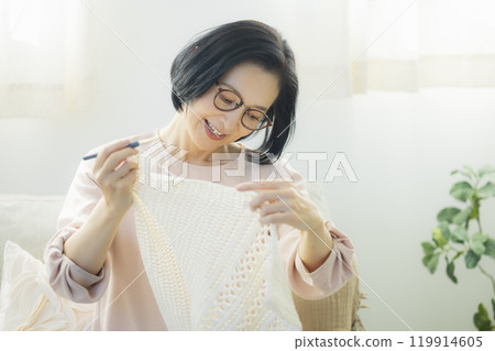 一位中年婦女在客廳織毛衣 119914605