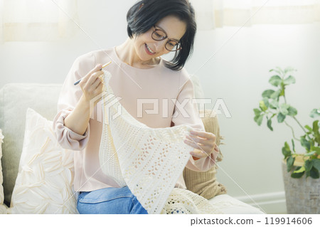 一位中年婦女在客廳織毛衣 119914606