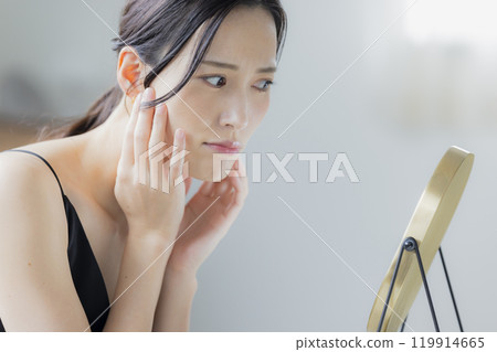 A woman doing skin care in the living room A woman doing skin care in the living room 119914665