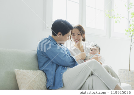 Young family, parents and children, living room 119915056