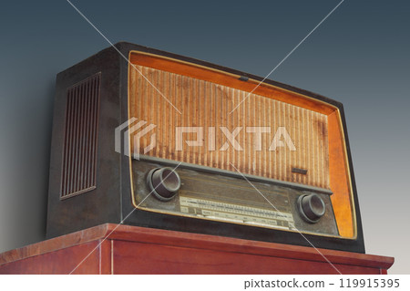 antique and old brown radio on red wooden table,  grey wall background, object, ancient, decor, fashion, template, copy space 119915395