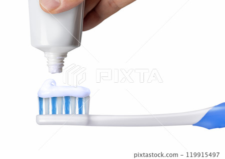 Hand putting toothpaste on a toothbrush Hand putting toothpaste on a toothbrush 119915497