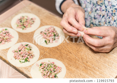 Senior woman making dumplings Senior woman making dumplings 119915793