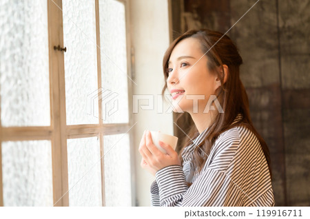 在窗口的婦女飲用的咖啡 119916711