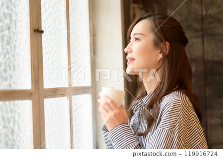 在窗口的婦女飲用的咖啡 在窗口的婦女飲用的咖啡 119916724