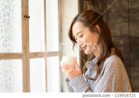 在窗口的婦女飲用的咖啡 在窗口的婦女飲用的咖啡 119916725