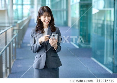 Young business woman in a suit looking at smartphone Young business woman in a suit looking at smartphone 119916749