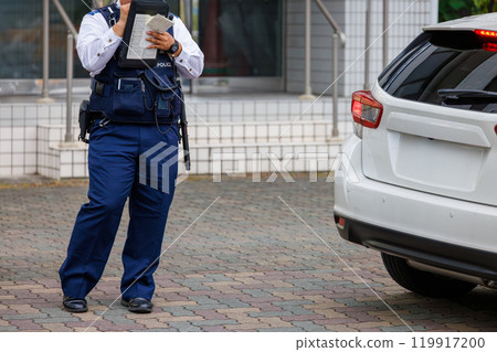 A police officer issuing a ticket to a driver who has committed a traffic violation 119917200