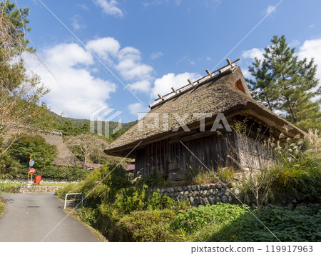 Thatched roof farm shed and autumn scenery 119917963