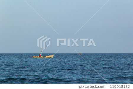 Small fishing boat floating in blue sea 119918182