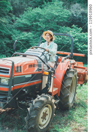 Woman driving a tractor 119918960