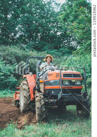 Young woman driving a tractor 119918962