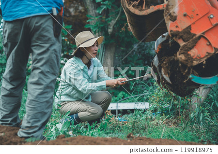 農民從拖拉機旋轉裝置上清除土壤 119918975