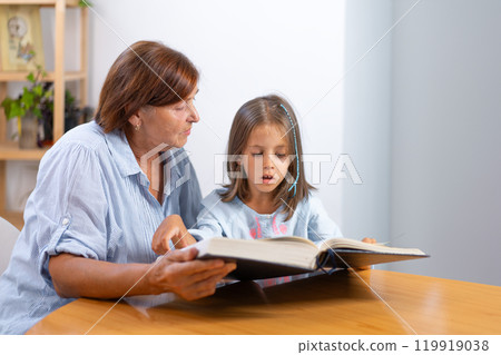 Grandmother and granddaughter reading book Grandmother and granddaughter reading book 119919038