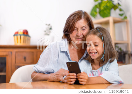 Happy granddaughter and grandmother using 119919041