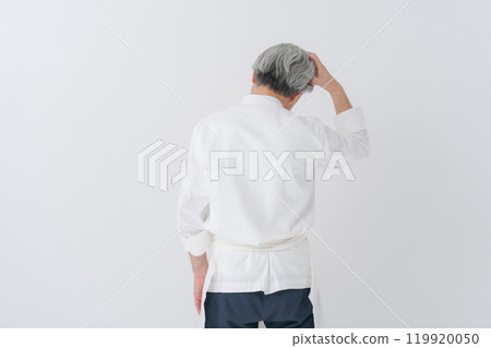 一個男廚師抱著頭的後視圖 一個男廚師抱著頭的後視圖 119920050
