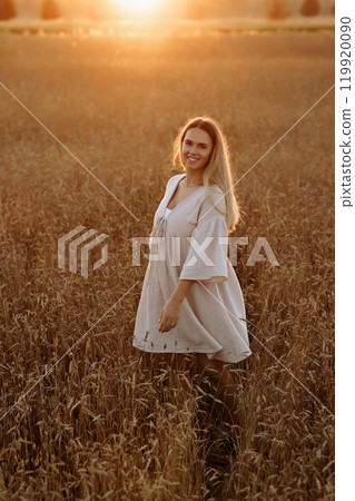 A woman is standing in a field of tall grass 119920090
