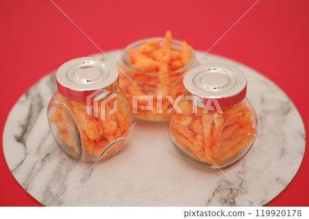 Crispy Corn Puffs in a jar on bamboo mat. Selective focus 119920178
