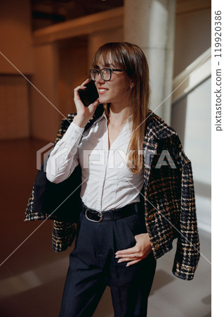 A Confident Businesswoman Poses in a Modern Office Setting That Exudes Professionalism and Style 119920386