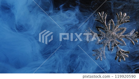 Xmas snowflake. Haze texture. Blue color ink water fog cloud shiny sparkling silver adornment on dark black background. Xmas snowflake. Haze texture. Blue color ink water fog cloud shiny sparkling silver adornment on dark black background. 119920590