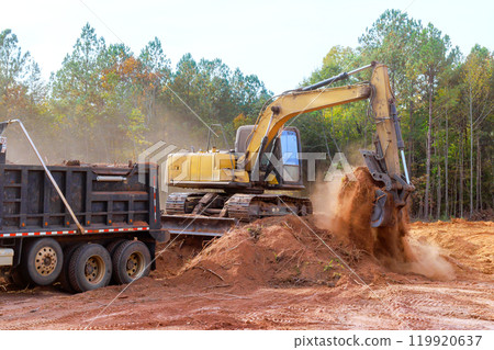 Process of loading earth into dump truck using an excavator at construction site 119920637