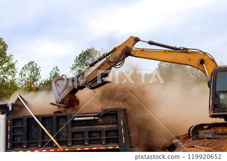 On construction site, excavators are used to process move earth into dump trucks On construction site, excavators are used to process move earth into dump trucks 119920652