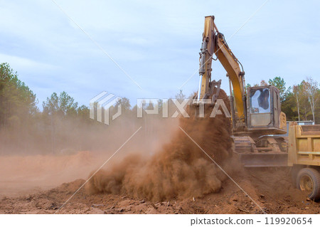 Loading earth into dump truck with assistance of an excavator Loading earth into dump truck with assistance of an excavator 119920654
