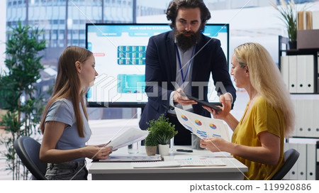 Financial advisor showing data graphs on big screen to customers, analyzing market trends to do forecasting. Mom and gen Z girl checking investment plan on display made by agent, camera B Financial advisor showing data graphs on big screen to customers, analyzing market trends to do forecasting. Mom and gen Z girl checking investment plan on display made by agent, camera B 119920886