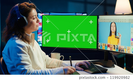 Photo editor using green screen monitor to color correct photographs in creative studio, listening music. Photographer selecting best pictures for editorial content with chroma key computer, camera A Photo editor using green screen monitor to color correct photographs in creative studio, listening music. Photographer selecting best pictures for editorial content with chroma key computer, camera A 119920982