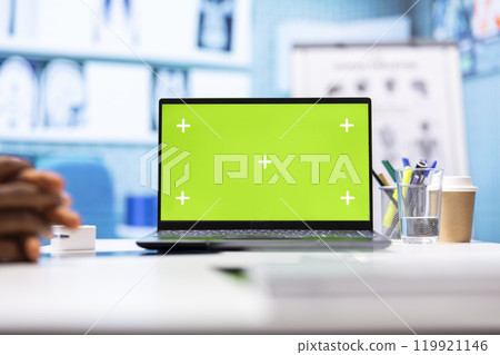 Doctor meeting with a patient in medical office next to copy space on display, employing medical technology at the hospital. Specialist physician helping a man with disease at check up. 119921146
