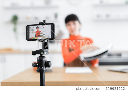 Caucasian female blogger reviews robot vacuum cleaner in modern kitchen Caucasian female blogger reviews robot vacuum cleaner in modern kitchen 119921212