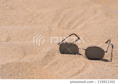 Sunglasses on the sand, giving a summer feel Sunglasses on the sand, giving a summer feel 119921302