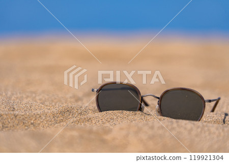 Sunglasses on the sand, giving a summer feel 119921304