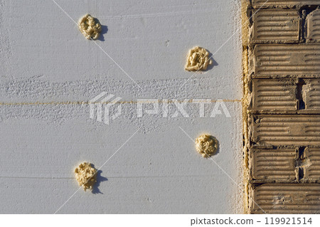 Styrofoam insulation panel with adhesive,brick wall, ready for installation 119921514