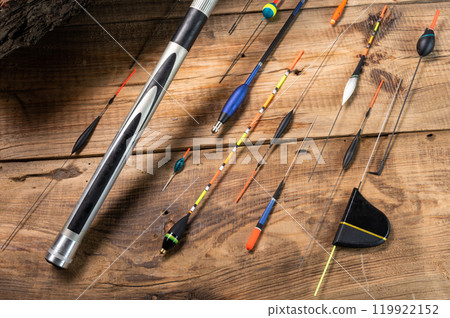Various fishing floats on a wooden background. Fishing rod and floats on wood. Fishing composition. 119922152