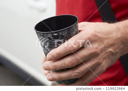 Coffee break. Man driver with a cup of coffee near the car 119922664