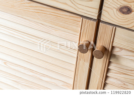 Wooden louvered doors with knob handles close-up view Wooden louvered doors with knob handles close-up view 119922820