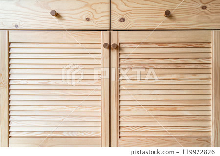 Wooden louvered doors with knob handles close-up view 119922826