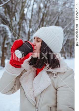 happy woman with coffee cup outdoors at winter cold day 119923496