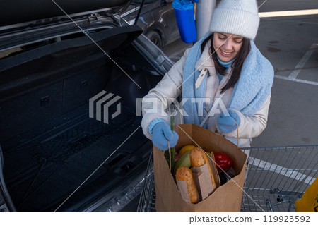 Woman uploading Groceries into Car Woman uploading Groceries into Car 119923592