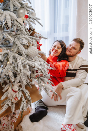 beautiful couple near christmas tree beautiful couple near christmas tree 119923607
