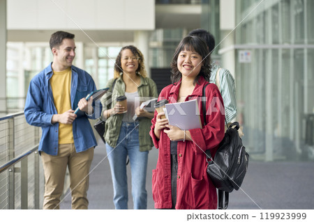 Smiling woman standing in front of a group of multinational students Smiling woman standing in front of a group of multinational students 119923999