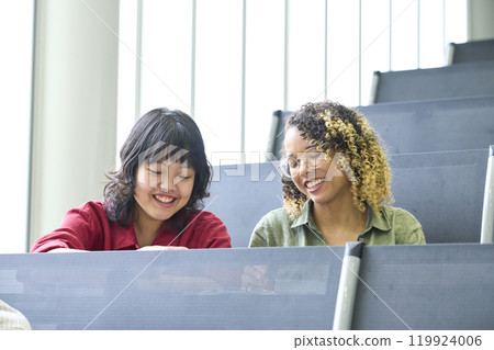 Group of multinational students having a conversation in a classroom Group of multinational students having a conversation in a classroom 119924006