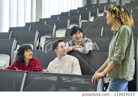 Group of multinational students having a conversation in a classroom Group of multinational students having a conversation in a classroom 119924013