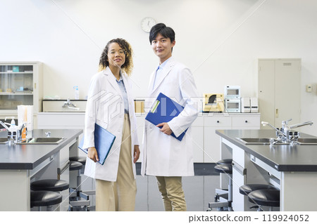Multinational group wearing white coats standing in a laboratory Multinational group wearing white coats standing in a laboratory 119924052